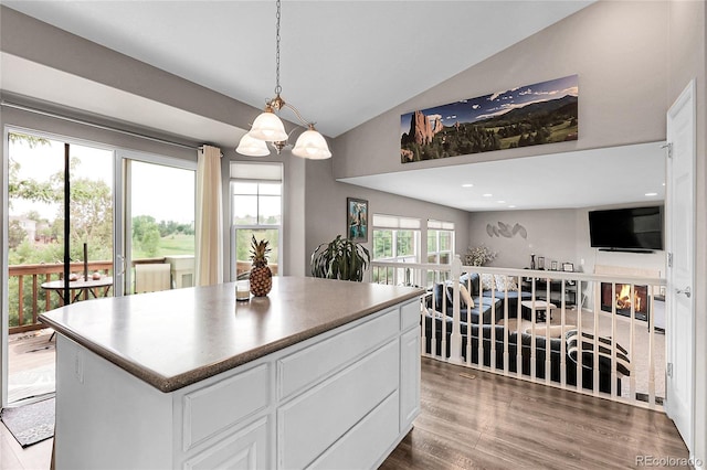 4912 S Fultondale Way, Aurora, CO 80016 - kitchen with vaulted ceiling, a chandelier, white cabinets, wood finished floors, and a kitchen island