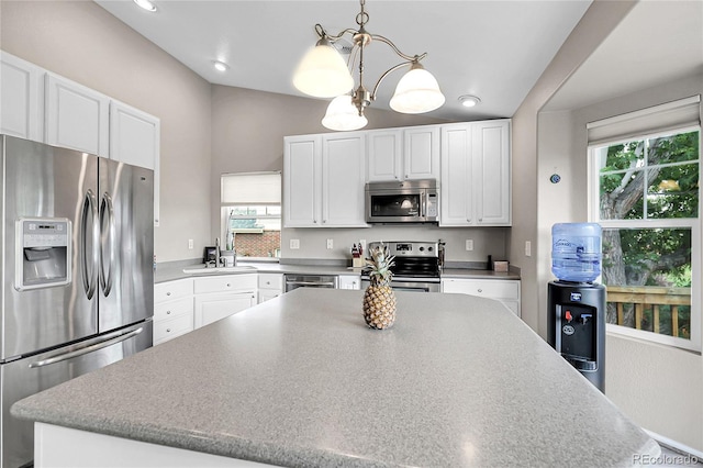 4912 S Fultondale Way, Aurora, CO 80016 - kitchen with stainless steel appliances, white cabinets, hanging light fixtures, a chandelier, and recessed lighting