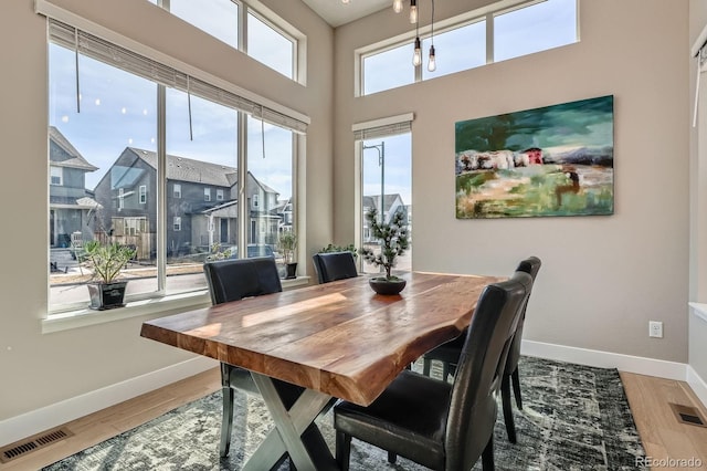 dining room with visible vents, baseboards, and wood finished floors