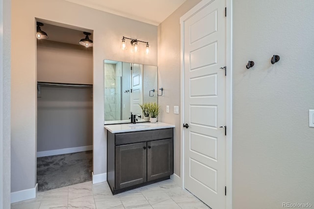 bathroom with vanity, baseboards, tiled shower, a spacious closet, and marble finish floor