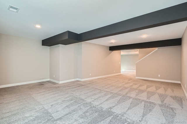 finished below grade area featuring recessed lighting, light colored carpet, visible vents, and baseboards