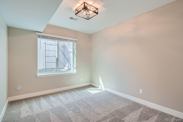 carpeted empty room featuring visible vents and baseboards