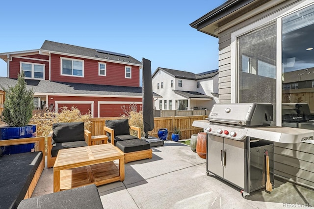 view of patio / terrace with a garage, fence, a residential view, and grilling area