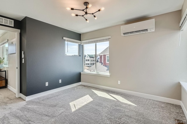 carpeted spare room with an inviting chandelier, baseboards, visible vents, and a wall mounted AC