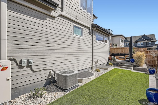 view of yard featuring outdoor lounge area, central air condition unit, fence, and a residential view