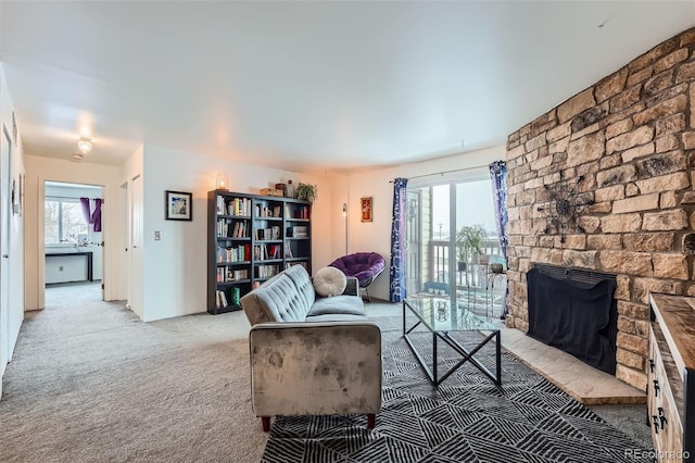 living room featuring a fireplace, plenty of natural light, and light carpet