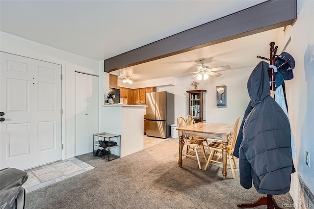 carpeted dining area featuring ceiling fan and beam ceiling