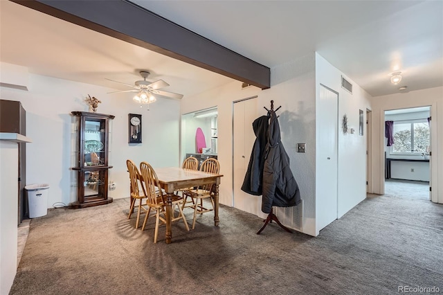 dining room featuring carpet flooring, ceiling fan, and beam ceiling