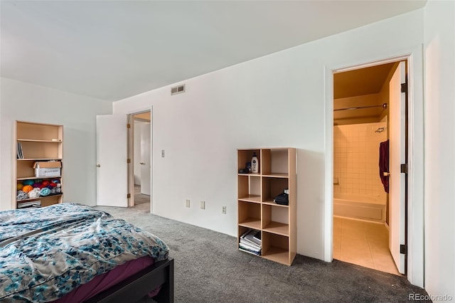 bedroom featuring ensuite bath and dark carpet