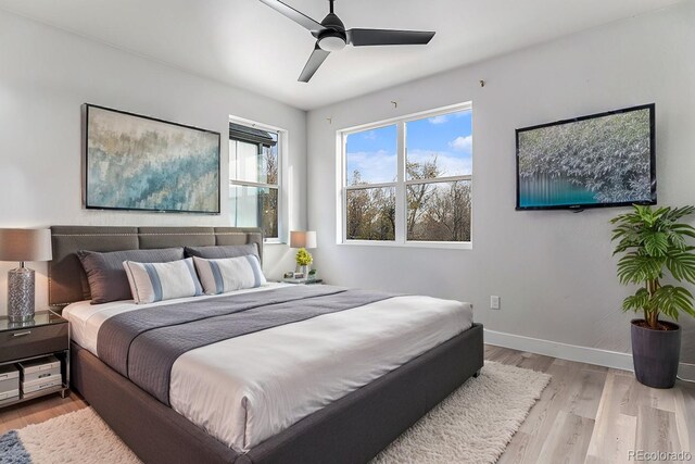 bedroom featuring light wood finished floors, baseboards, and ceiling fan