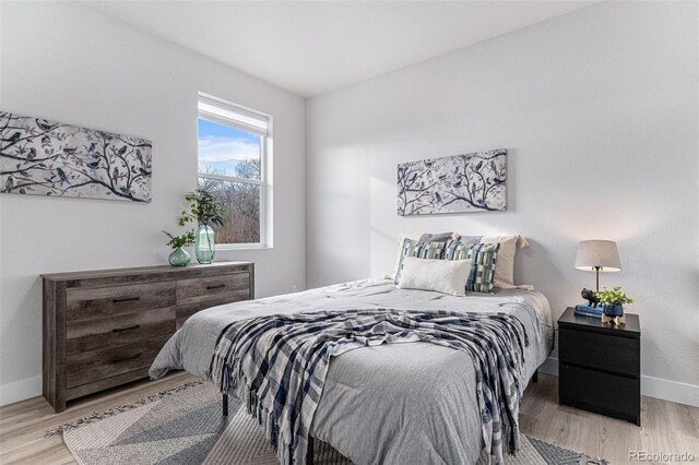 bedroom with light wood finished floors and baseboards