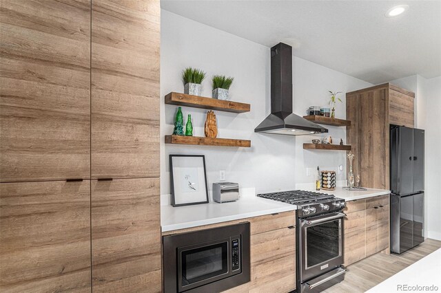kitchen with open shelves, modern cabinets, appliances with stainless steel finishes, and wall chimney range hood