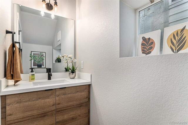 bathroom featuring a textured wall and vanity