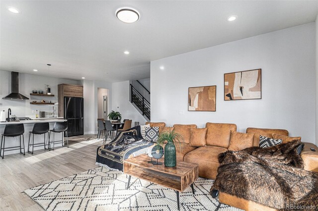 living area with recessed lighting, stairway, and light wood-style flooring