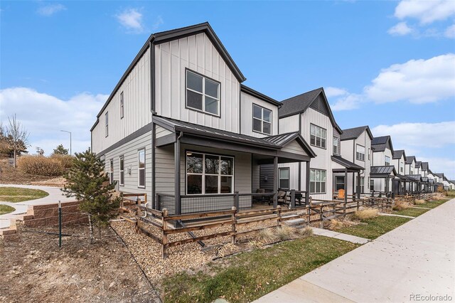 view of front of house with a residential view, board and batten siding, a standing seam roof, a porch, and metal roof
