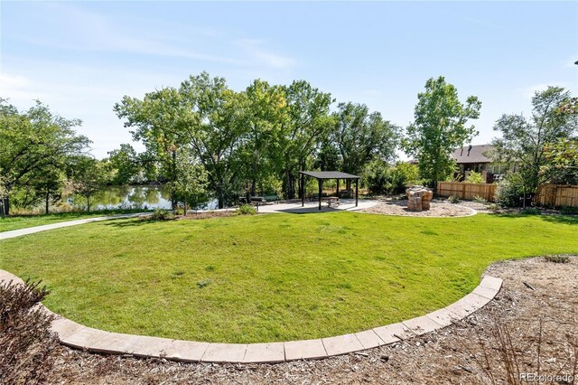 view of property's community featuring fence, a gazebo, a yard, and a patio