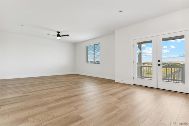 empty room featuring french doors, a ceiling fan, baseboards, and light wood finished floors