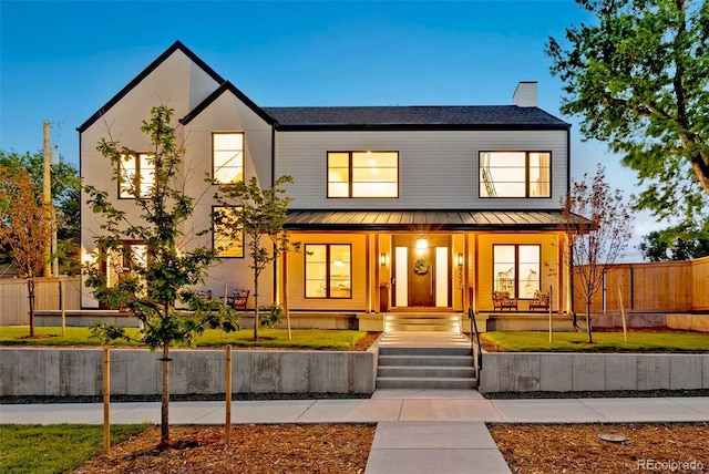 4520 W Moncrieff Pl, Denver, CO 80212 - view of front of house featuring a standing seam roof, a porch, a metal roof, and a chimney