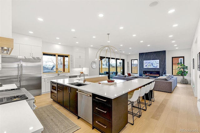 4520 W Moncrieff Pl, Denver, CO 80212 - kitchen featuring built in appliances, a spacious island, white cabinets, light countertops, and recessed lighting