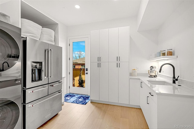 4520 W Moncrieff Pl, Denver, CO 80212 - kitchen featuring high end fridge, stacked washer and clothes dryer, light wood-type flooring, light countertops, and white cabinets