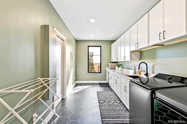 4520 W Moncrieff Pl, Denver, CO 80212 - laundry area with washing machine and dryer, cabinet space, dark tile patterned floors, and recessed lighting