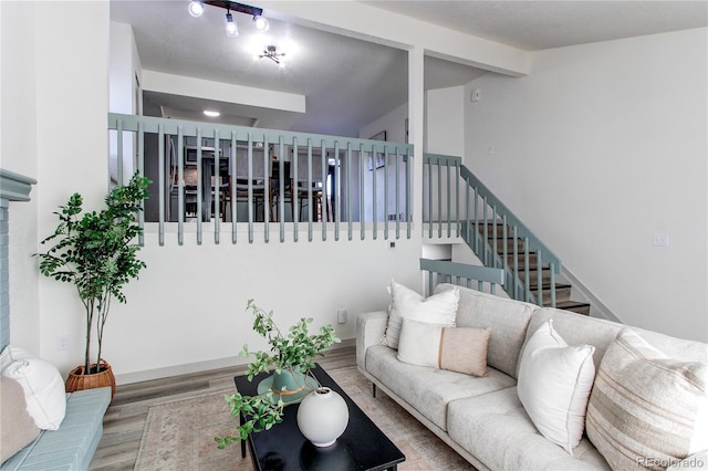 living area featuring wood finished floors and lofted ceiling with beams