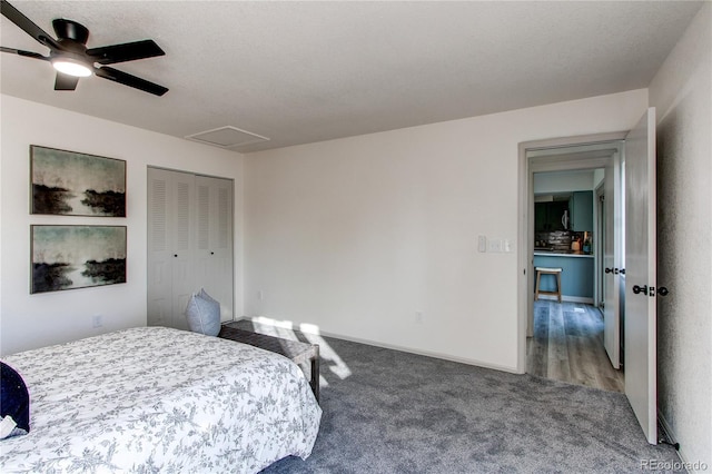 carpeted bedroom featuring baseboards, a closet, a textured ceiling, attic access, and ceiling fan