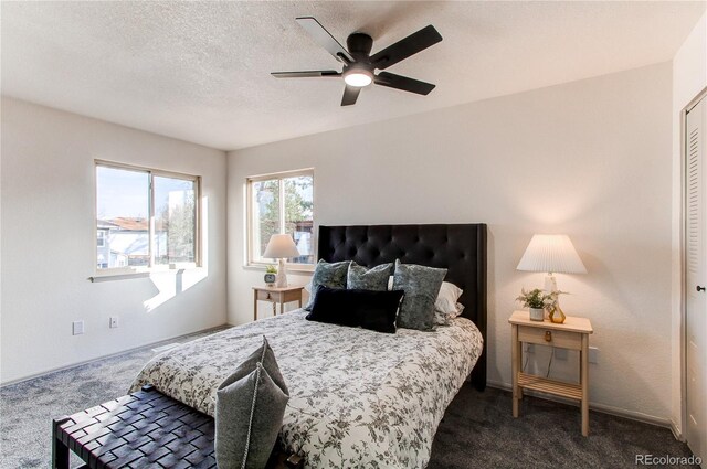 bedroom featuring a textured ceiling, dark carpet, and ceiling fan