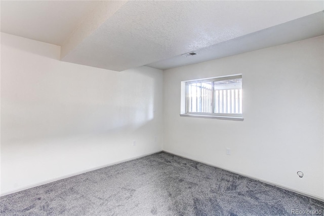 unfurnished room featuring visible vents, baseboards, carpet flooring, and a textured ceiling