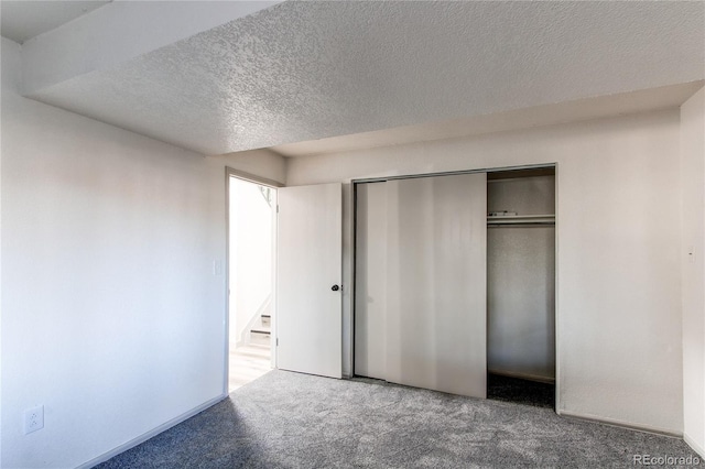 unfurnished bedroom featuring a closet, carpet floors, and a textured ceiling