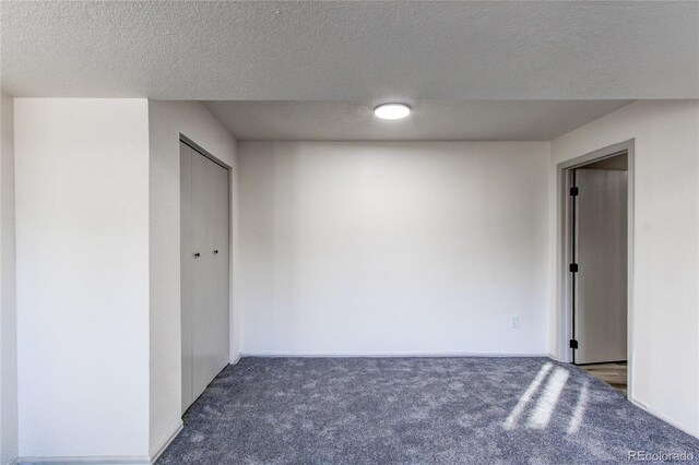carpeted spare room featuring a textured ceiling