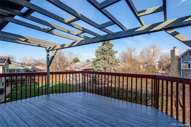 wooden deck featuring a yard and a pergola