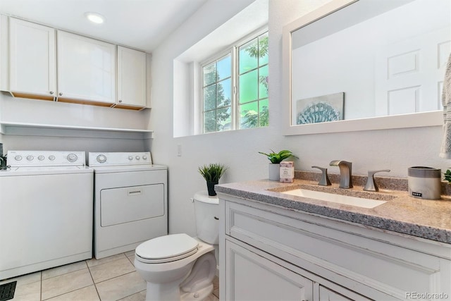 bathroom with washing machine and clothes dryer, vanity, tile patterned floors, and toilet