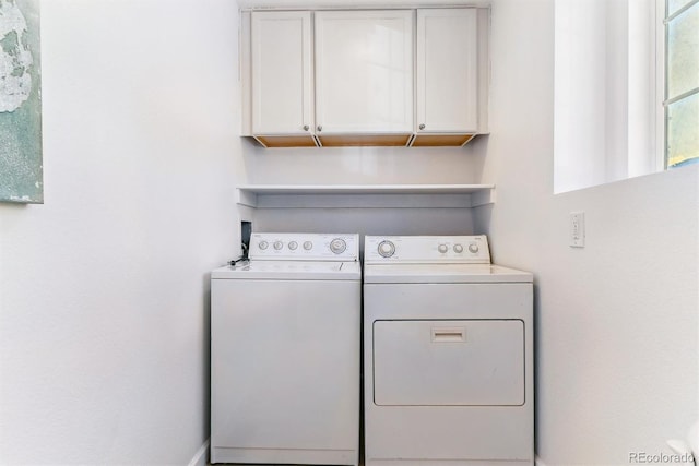 laundry room featuring independent washer and dryer and cabinets