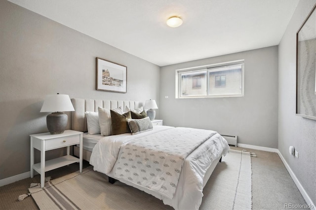 bedroom featuring a baseboard heating unit, baseboards, and carpet floors
