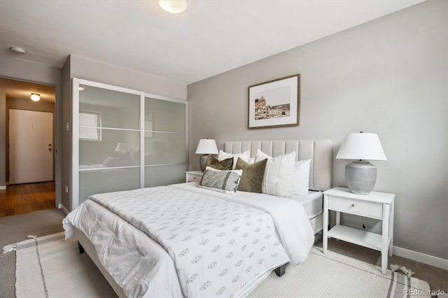 bedroom with carpet, baseboards, and a closet