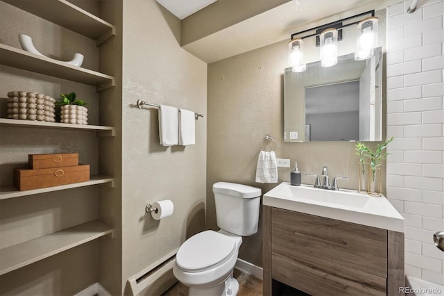 bathroom with baseboard heating, toilet, vanity, and baseboards