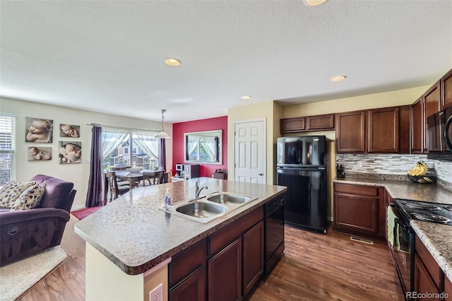 5280 Raritan Way, Denver, CO 80221 - kitchen with black appliances, tasteful backsplash, pendant lighting, an island with sink, and dark wood-style floors