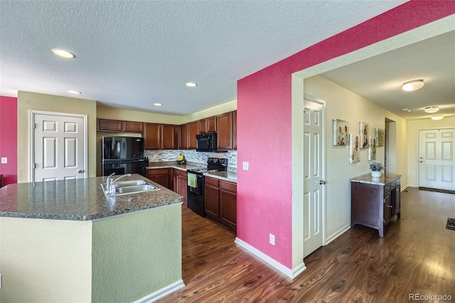 5280 Raritan Way, Denver, CO 80221 - kitchen featuring black appliances, dark wood-style flooring, a textured ceiling, a kitchen island with sink, and recessed lighting