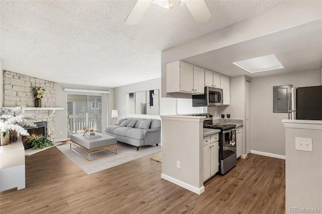 kitchen with stainless steel appliances, white cabinetry, ceiling fan, and hardwood / wood-style floors