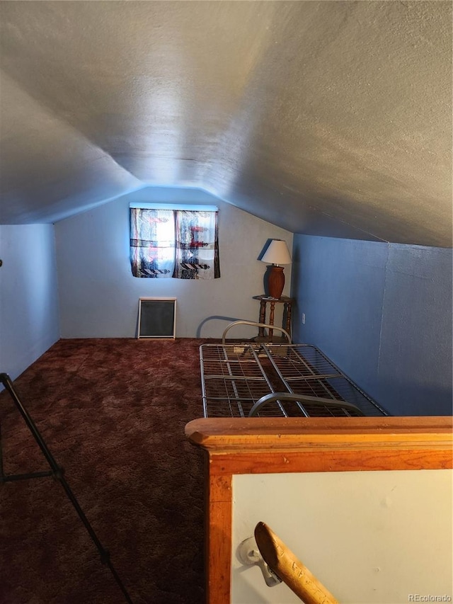 game room with vaulted ceiling, a textured ceiling, and carpet flooring