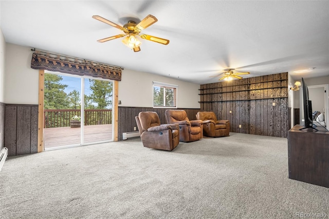 11608 Apache Trl, Conifer, CO 80433 - living room with ceiling fan, wooden walls, a baseboard radiator, carpet floors, and a wainscoted wall