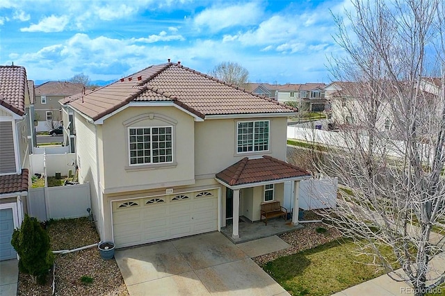 view of front of property featuring concrete driveway, a garage, fence, and a tile roof