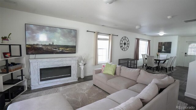 living room featuring a fireplace, visible vents, and baseboards