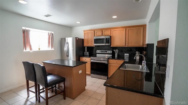 kitchen with dark countertops, a sink, visible vents, and stainless steel appliances