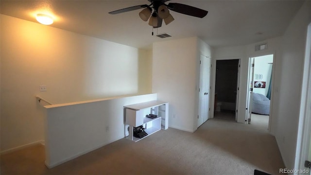 spare room featuring ceiling fan, carpet, and visible vents