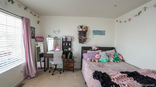 carpeted bedroom featuring visible vents, baseboards, and multiple windows
