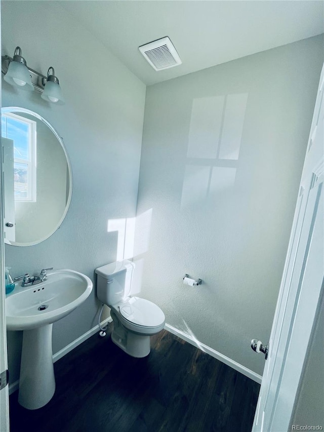 bathroom with toilet and hardwood / wood-style flooring