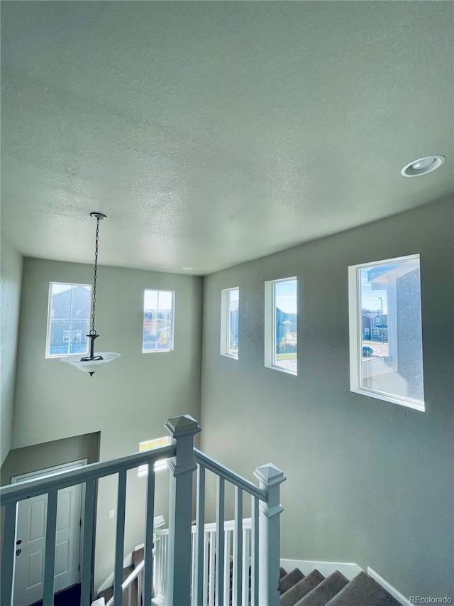 stairway featuring a textured ceiling