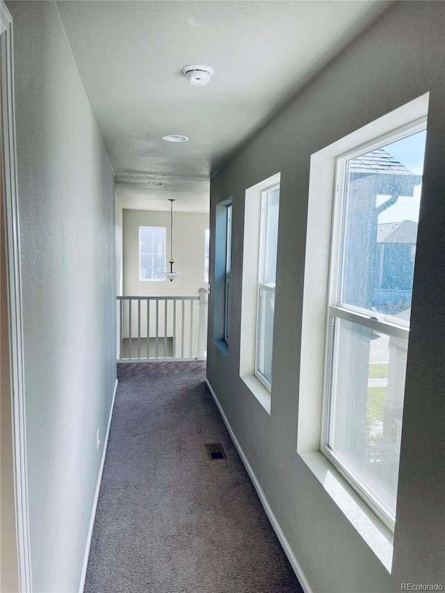 hallway with dark colored carpet